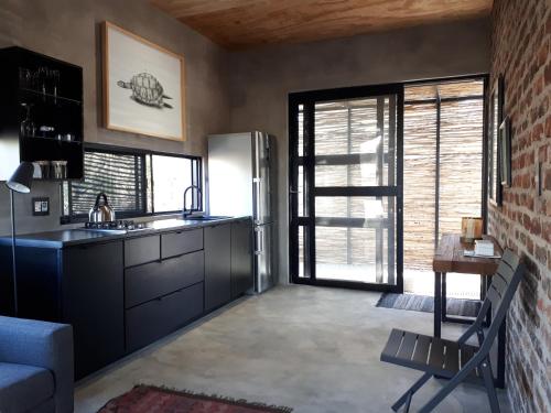 - une cuisine avec un réfrigérateur et une table dans la chambre dans l'établissement Terrapin Studio, à Marloth Park