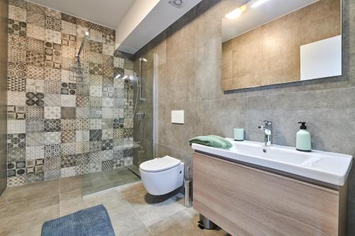 La salle de bains est pourvue d'un lavabo, de toilettes et d'une douche. dans l'établissement Apartmani Ivana, à Umag