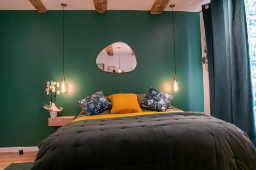 una camera da letto con un grande letto con una parete verde di studio coeur de ville neuf et design tt equipé parking gratuit a Sanary-sur-Mer