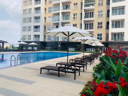una piscina con bancos y sombrillas frente a un edificio en Homestay sea view Newlife Halong., en Ha Long