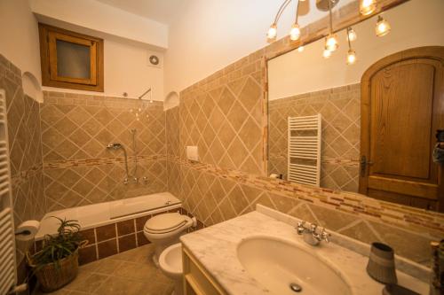 ein Badezimmer mit einem Waschbecken, einem WC und einem Spiegel in der Unterkunft Casa Giulia Positano in Positano