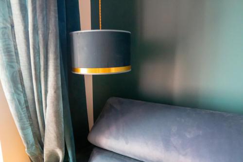 a lamp sitting next to a bed next to a curtain at coeur de ville t2, terrasse, clim tt équipe, parking in Sanary-sur-Mer