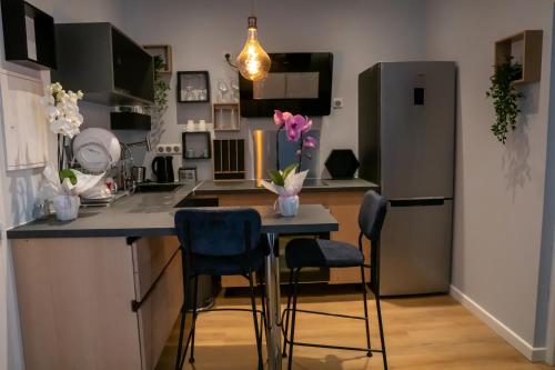 uma cozinha com um frigorífico e uma mesa com cadeiras em coeur de ville t2, terrasse, clim tt équipe, parking em Sanary-sur-Mer
