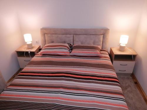 a bedroom with a large bed with two lamps on night stands at Marina in Budva