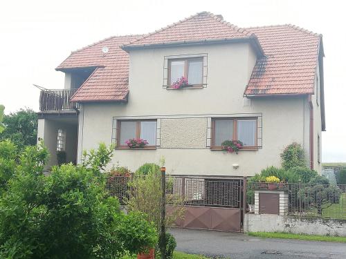 a white house with windows and a fence at Apartmán Za kostelem in Zvole