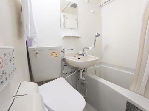 a bathroom with a sink and a toilet and a tub at Value the Hotel Ishinomaki in Ishinomaki