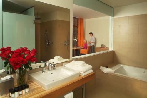 un baño con lavabo y una persona en un espejo en Inn at Lenape Heights-Golf Resort and Event Center, en Ford City
