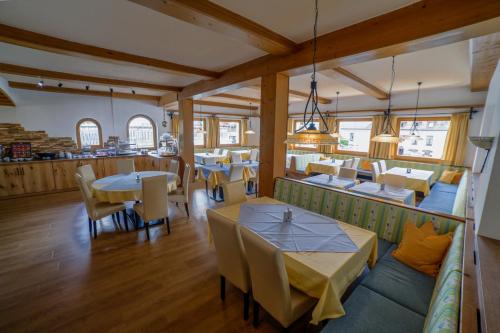 a restaurant with tables and chairs in a room at Pension Garni Hochmoos in Lermoos
