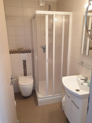 La salle de bains est pourvue d'une douche, de toilettes et d'un lavabo. dans l'établissement Ferienwohnung Julia, à Emden