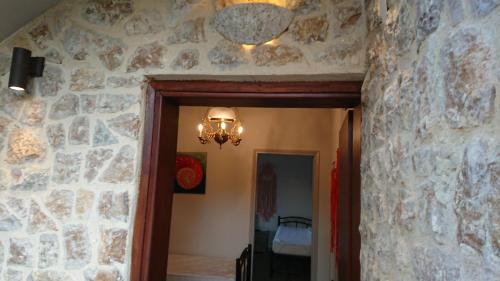 a hallway with a stone wall and a chandelier at Stone house with seaview in Nea Potidaea