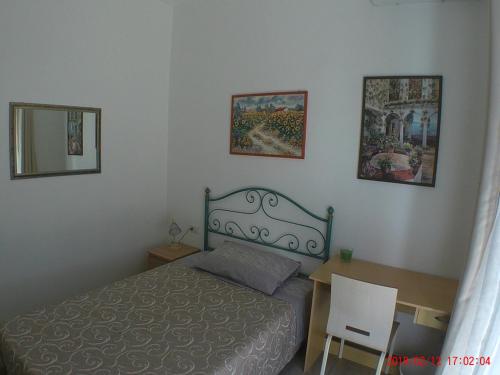 a bedroom with a bed and a desk and a mirror at un passo dal mare in Fiumicino