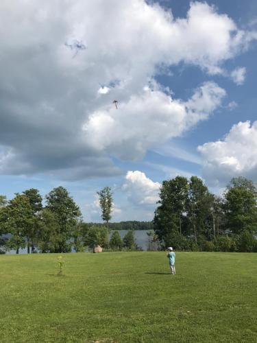 a person is flying a kite in a field at Medumi Lake Villa in Medumi