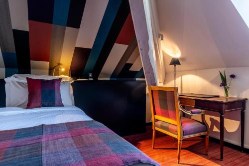 a bedroom with a bed and a desk and a chair at La Chapelle Saint Martin in Nieul