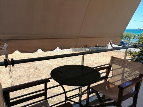 a table and chairs on a balcony with the beach at Jason Rooms & Studios in Keratokampos