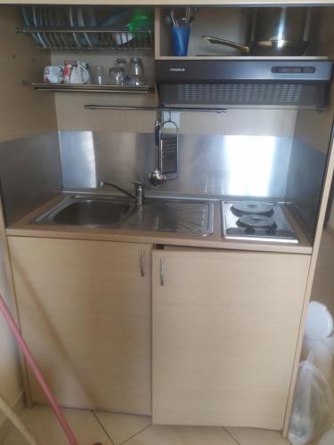 a kitchen with a sink and a stove at Bella Vista Apartments in Nea Vrasna
