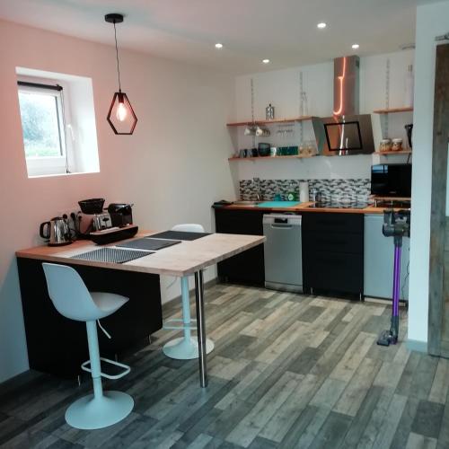 Il comprend une cuisine avec une table et des chaises en bois. dans l'établissement La Petite Pause, à Verlinghem