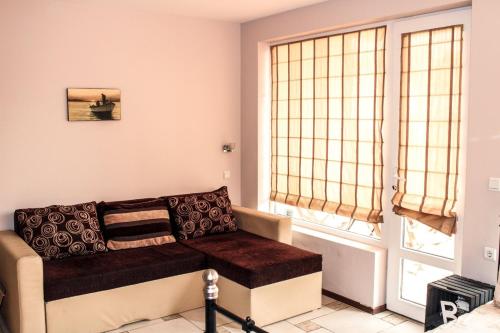 uma sala de estar com um sofá e uma janela em La Mer Apartment em Rogachevo