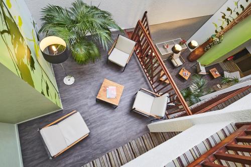 an overhead view of a lobby with tables and chairs at Kyriad Hotel Nevers Centre in Nevers