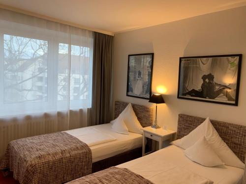 Кровать или кровати в номере Hotel Nymphenburg City - München