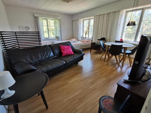 - un salon avec un canapé en cuir noir et une table dans l'établissement Kotkan Residenssi Apartments, à Kotka