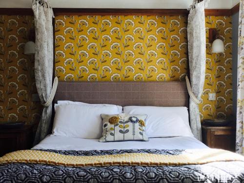 a bedroom with a bed with a yellow headboard at The Inn on the Moor Hotel in Goathland