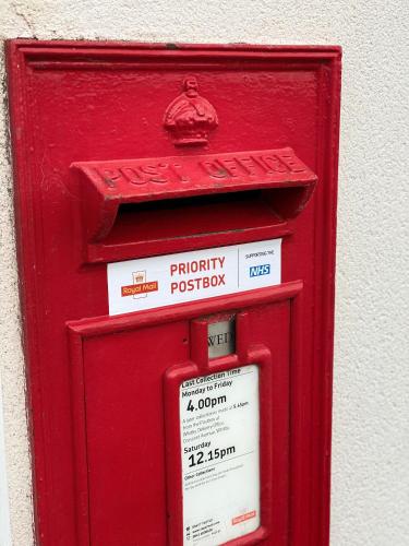 a red pillar box with a sign on it at The Inn on the Moor Hotel in Goathland