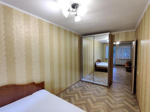 a bedroom with a bed and a room with a mirror at Filatov apartment in Odesa