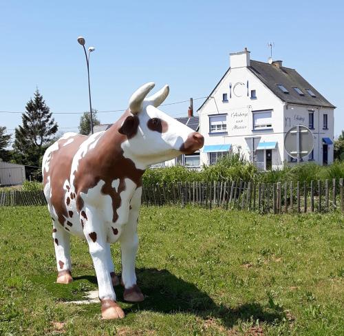 a statue of a cow standing in a field at Auberge aux Marais in Montmartin-en-Graignes