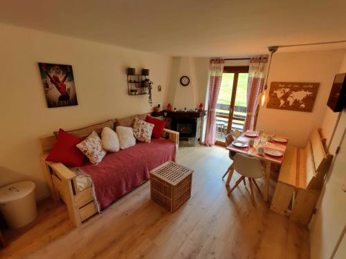 een slaapkamer met een rood bed, een tafel en een bureau bij Skichalet Cervinia Martino e Bassi apt Sandrino and Elena in Breuil-Cervinia