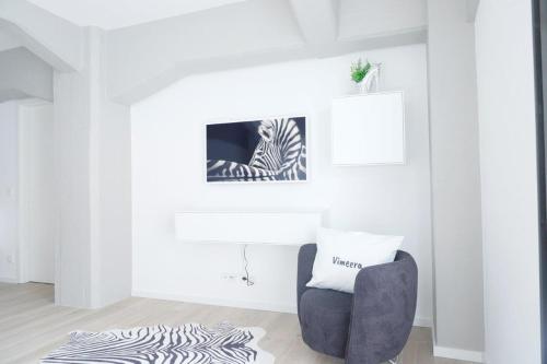 un soggiorno bianco con tappeto zebrato e sedia di Speicher Residenz Barth E2 App 1 a Barth