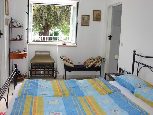 1 dormitorio con 2 camas y ventana en Villa Bruna Apartment, en Rab