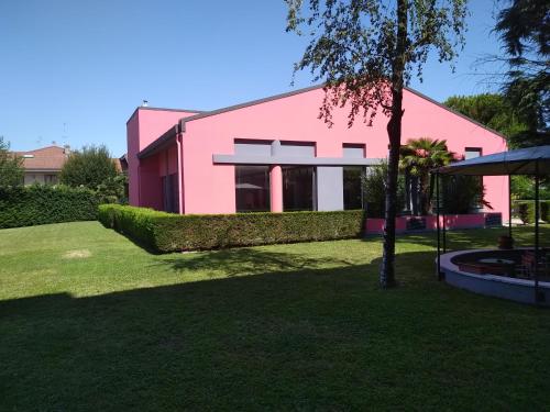 a pink building with a tree in front of it at Hotel Embassy in Pero