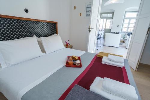 a bedroom with a bed with a tray of food on it at LIVIN Hydra Legacy Suite in Hydra