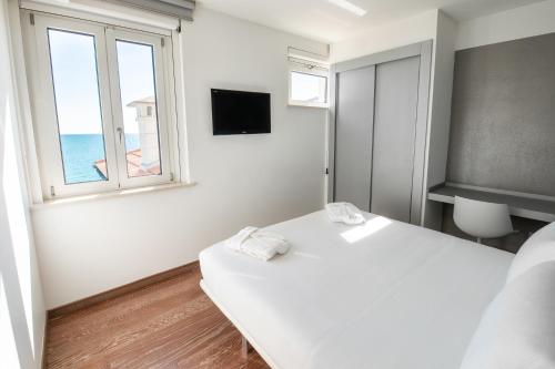 a white room with a bed and a window at Life Hotel Seaview & Spa in Porto Recanati