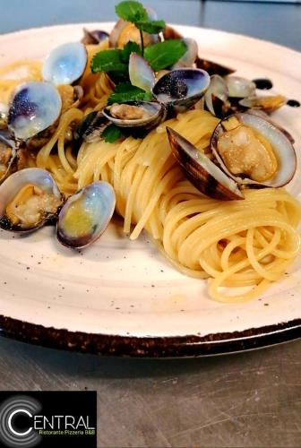a plate of pasta and mussels on a table at Central in Casarile