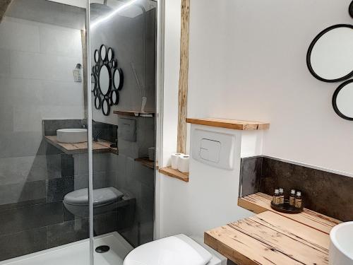 een badkamer met een toilet en een glazen douche bij La maison basse in Saint-Dalmas-le-Selvage