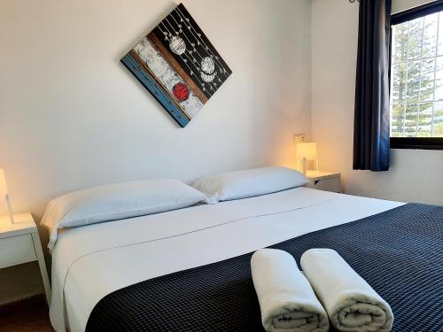 1 dormitorio con 1 cama blanca grande y toallas. en Hostal Costa, en Ibiza