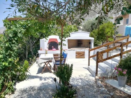 a garden with a white house with a stove at Sylvia's houses in Kalymnos