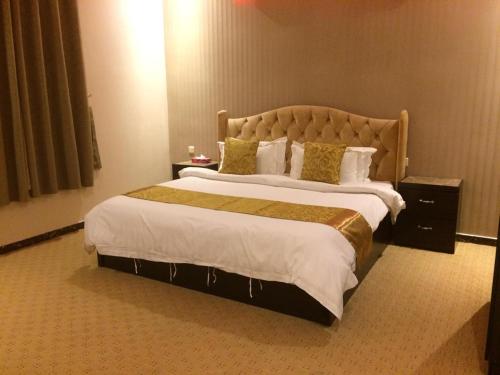 une chambre avec un grand lit dans une chambre d'hôtel dans l'établissement اوراد رويال 1, à Riyad