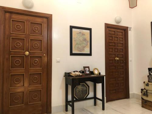 a room with two wooden doors and a table at El Zaguán de la Plata in Fuente de Cantos