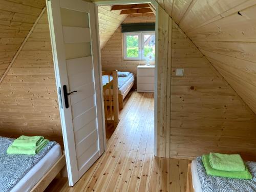 a room with two beds in a wooden cabin at Mazurska Zagroda Domek Letniskowy in Rydzewo