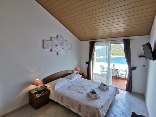 - une chambre avec un lit et une vue sur l'océan dans l'établissement Apartments Marija, à Lastovo