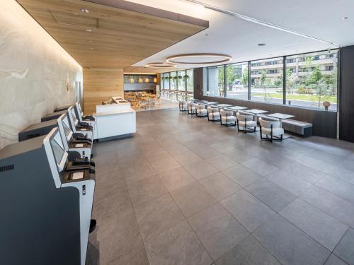 a large lobby with chairs and tables and windows at Far East Village Hotel Tokyo Ariake in Tokyo