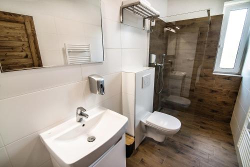 a bathroom with a sink and a toilet and a shower at Apartmany JA&MA in Liptovský Mikuláš