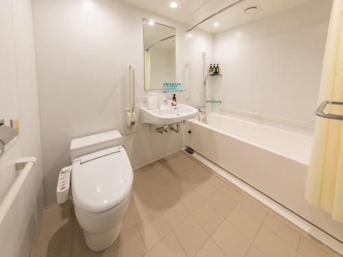 a white bathroom with a toilet and a sink at Far East Village Hotel Tokyo Ariake in Tokyo