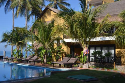 ein Resort mit Palmen und einem Pool in der Unterkunft Rang Garden Beach Side in Mui Ne