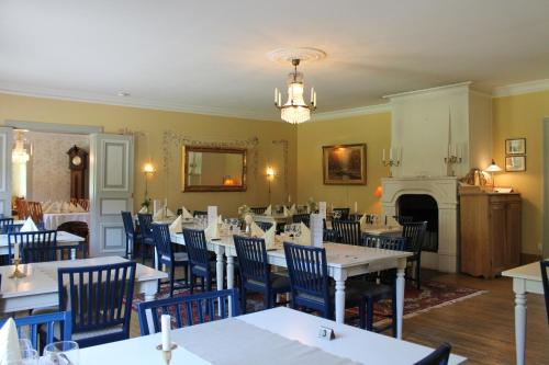 a dining room with tables and chairs and a fireplace at Wanbo Herrgård in Nedre Vanbo