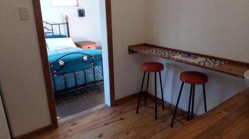 Camera piccola con letto e 2 sgabelli. di Corner Cottage Rear Studio - Attached - Geneva in Kyogle a Kyogle
