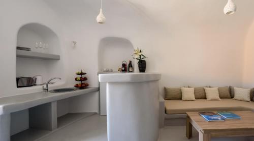 a white living room with a couch and a table at White Dream Suites in Fira