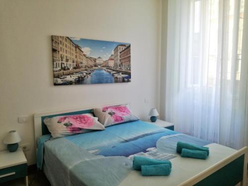 a bedroom with a bed with a painting on the wall at Trieste Center Rooms & Apartments - Fiori di Trieste in Trieste